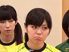 Unga japanska tjejer lär av sin tränare i en het grupplektion